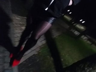 crossdresser walking in public park in heels