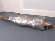 Blonde girl wrapped in duct tape struggles