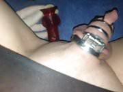 Sissy in chastity playing with red dildo