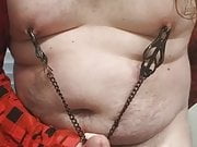 Fat boy rubbing cock with nipple clamps on