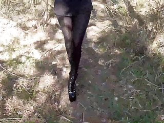 walking wearing a black dress pantyhose and heels