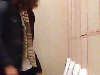 Long haired guy pissing at urinals