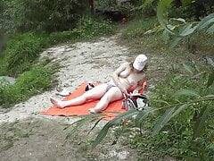 Wild beach. Random passerby guy peeps on river bank sunbathing topless beautiful Milf Outdoors. Outside. Naked in public